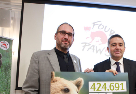 Two men holding a signature sign