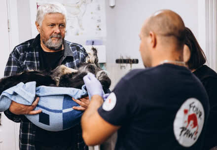 Man with dog in his arms at the veterinary