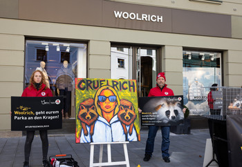 Demonstration in front of the Woolrich store in Munich with a painting