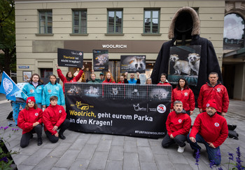 Demonstration in front of the Woolrich store in Munich with a giant parka and banner